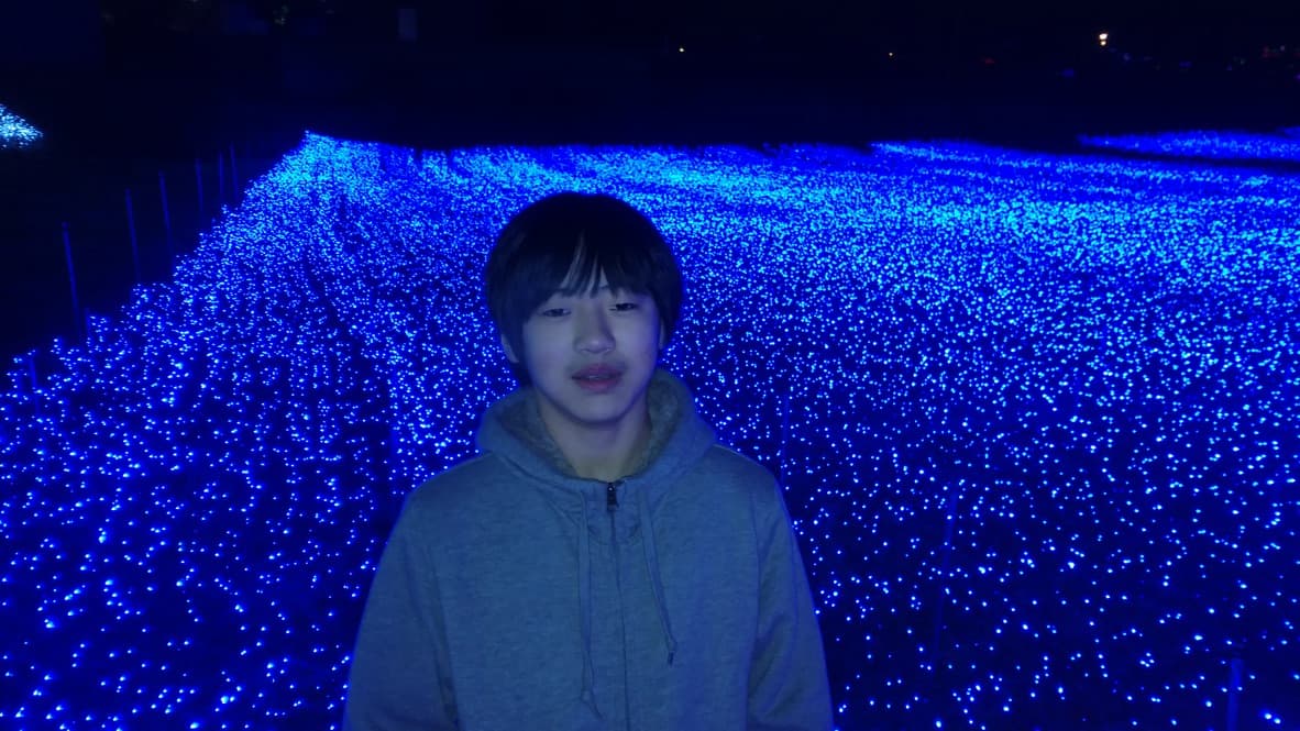 푸른 LED 정원을 배경으로 회색 후드티를 입은 고3 시절의 여준수